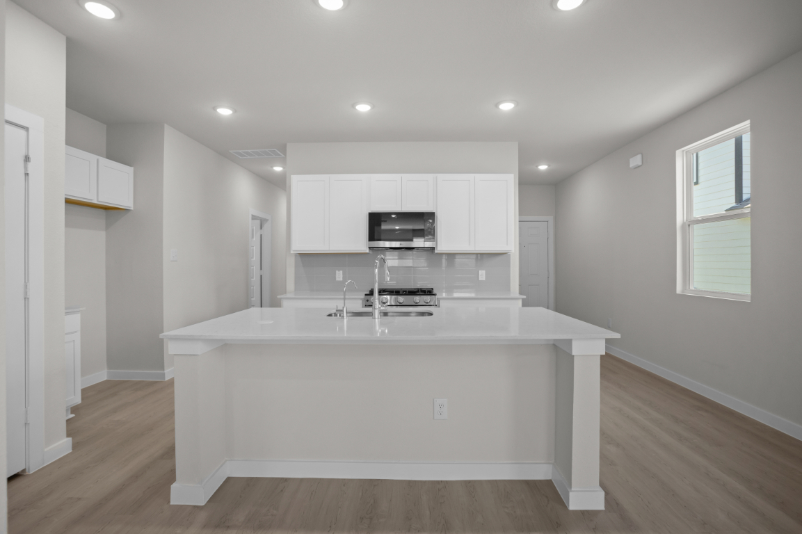A kitchen with white cabinets.
