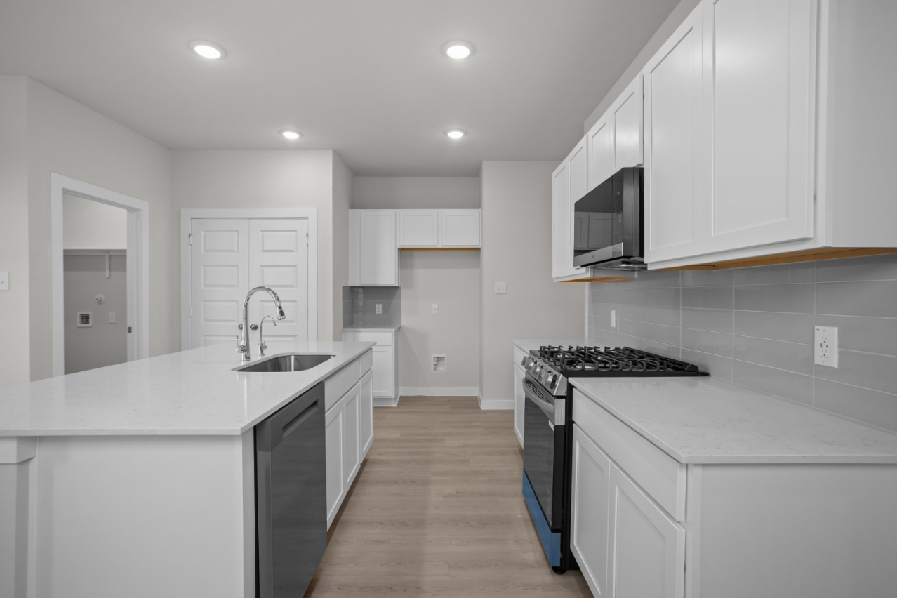 A kitchen with white cabinets.