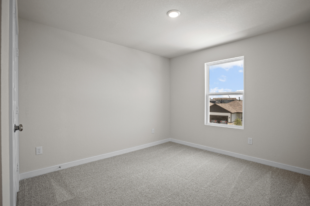 A room with a window and a carpet.