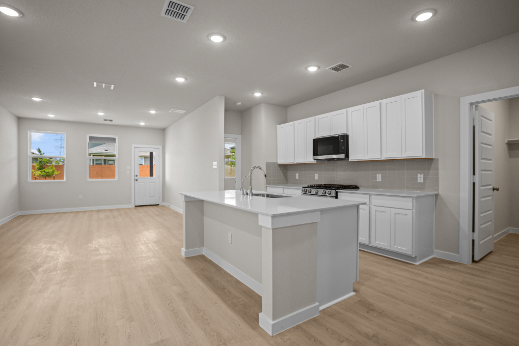 A kitchen with white cabinets.