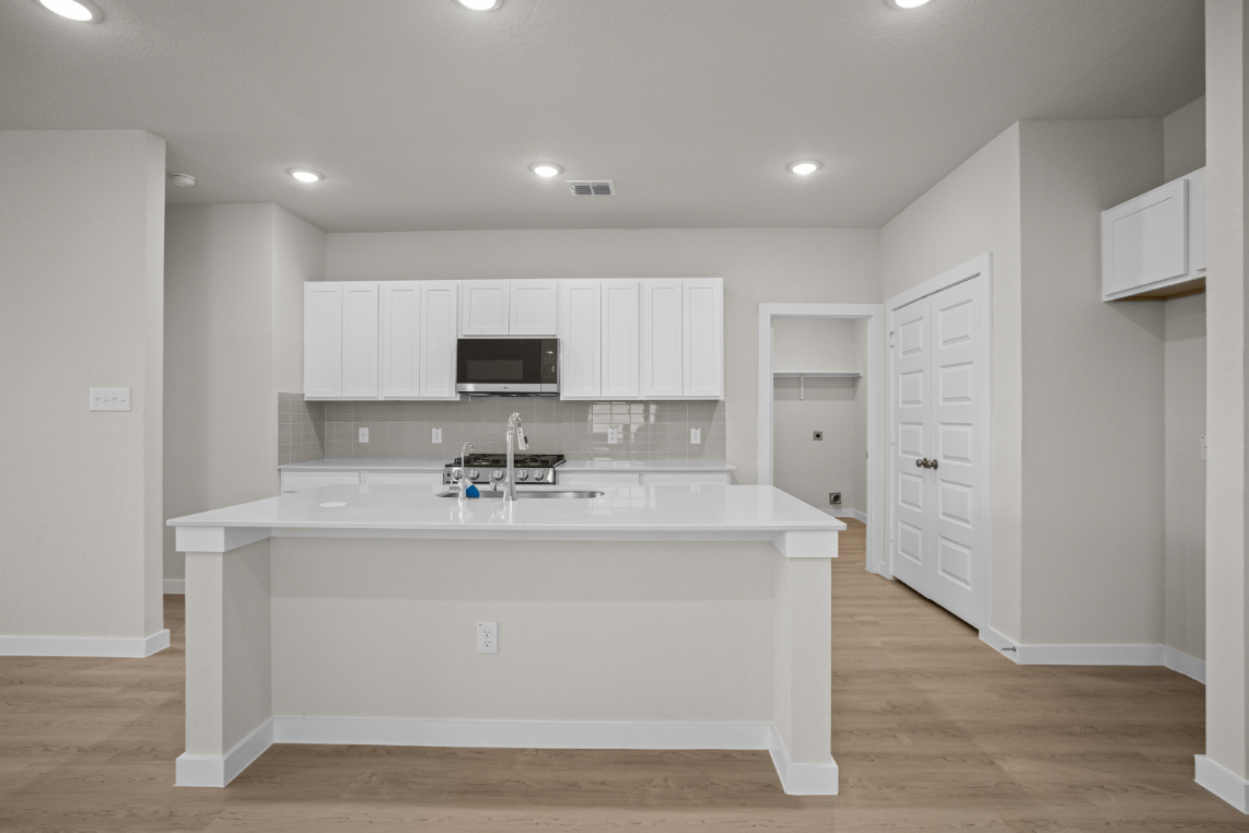 A kitchen with white cabinets.