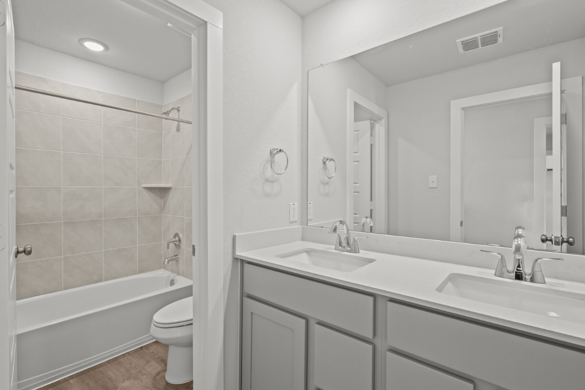 A bathroom with a tub sink and toilet.