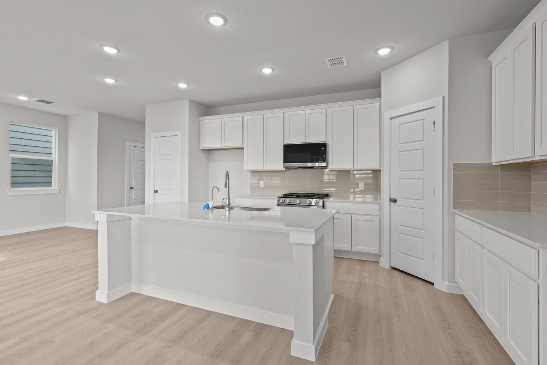 A kitchen with white cabinets.