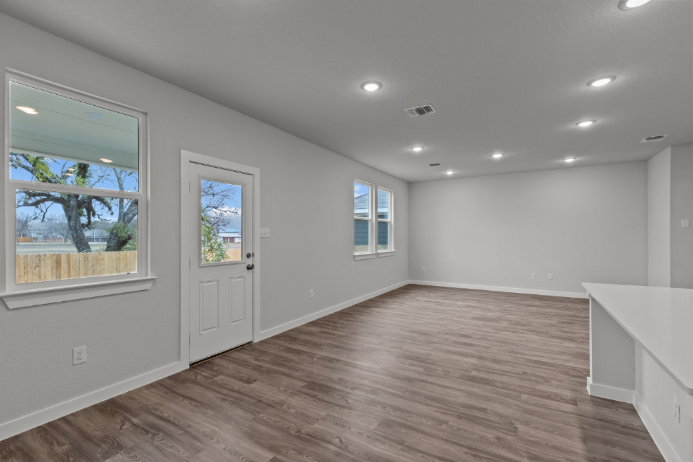 A room with a wood floor and windows.