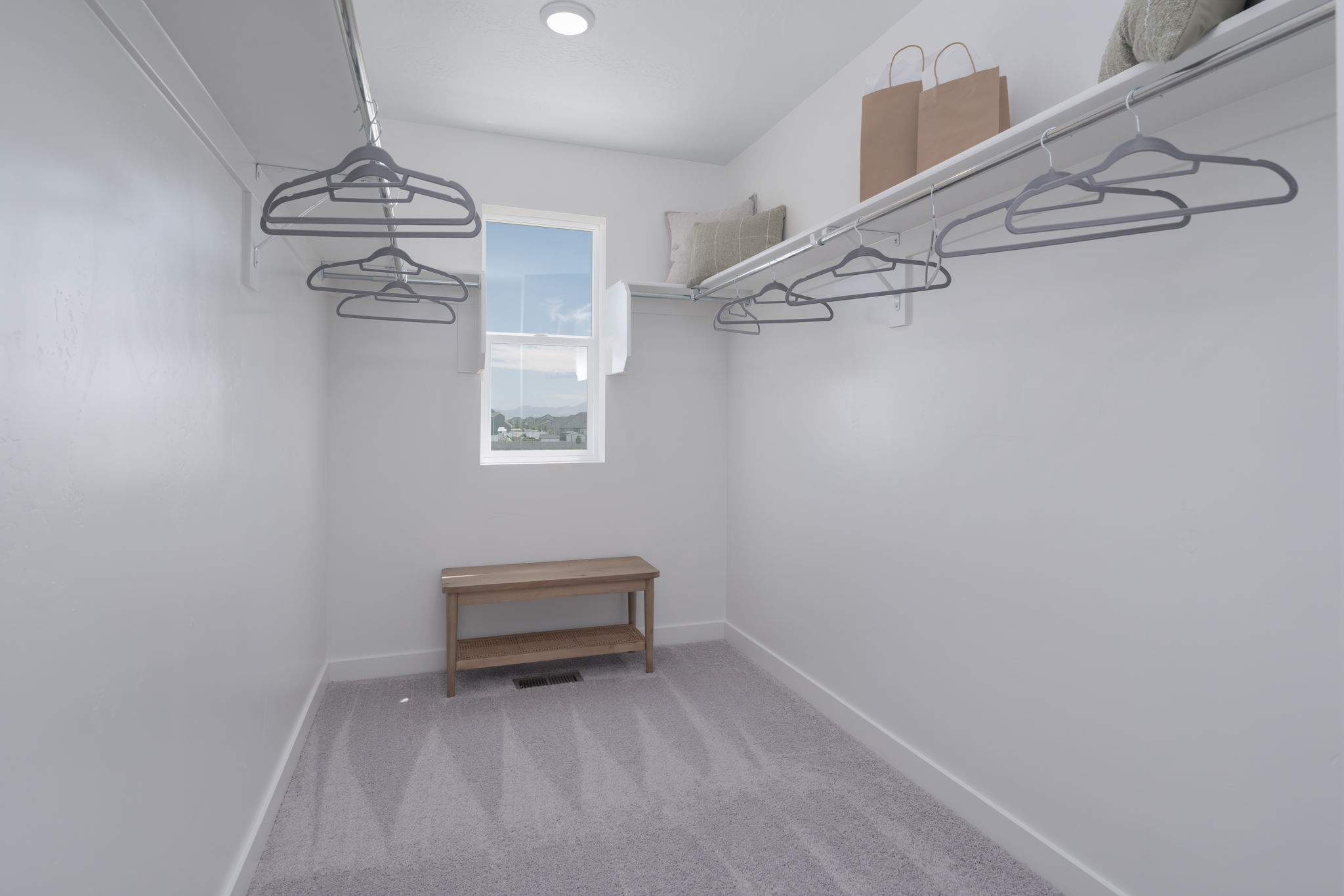 A room with a bench and a shelf with a lamp on it.