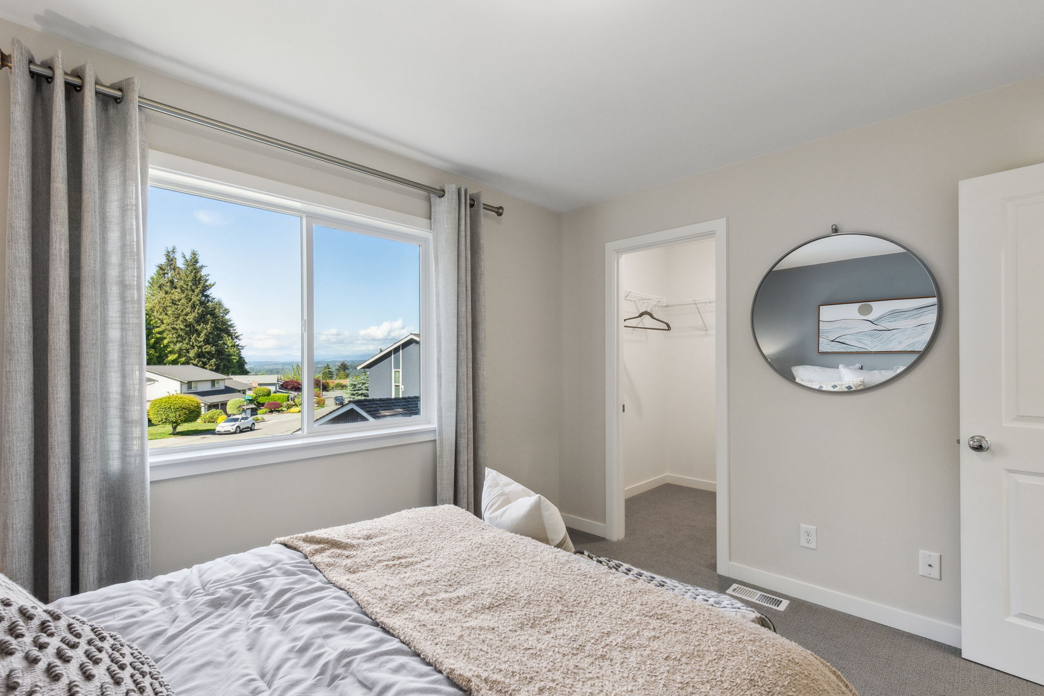 A bedroom with a large window.