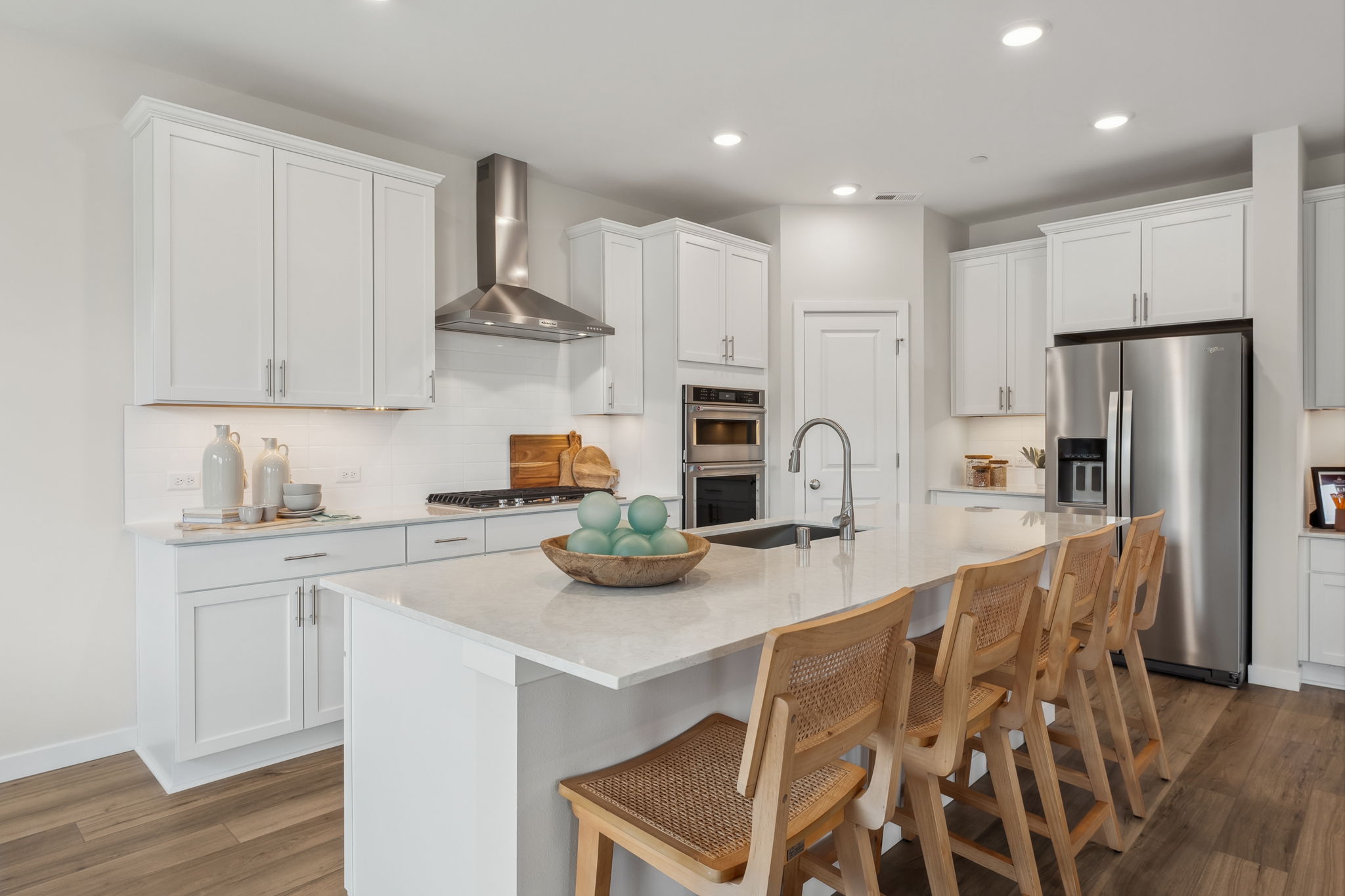 A kitchen with white cabinets.