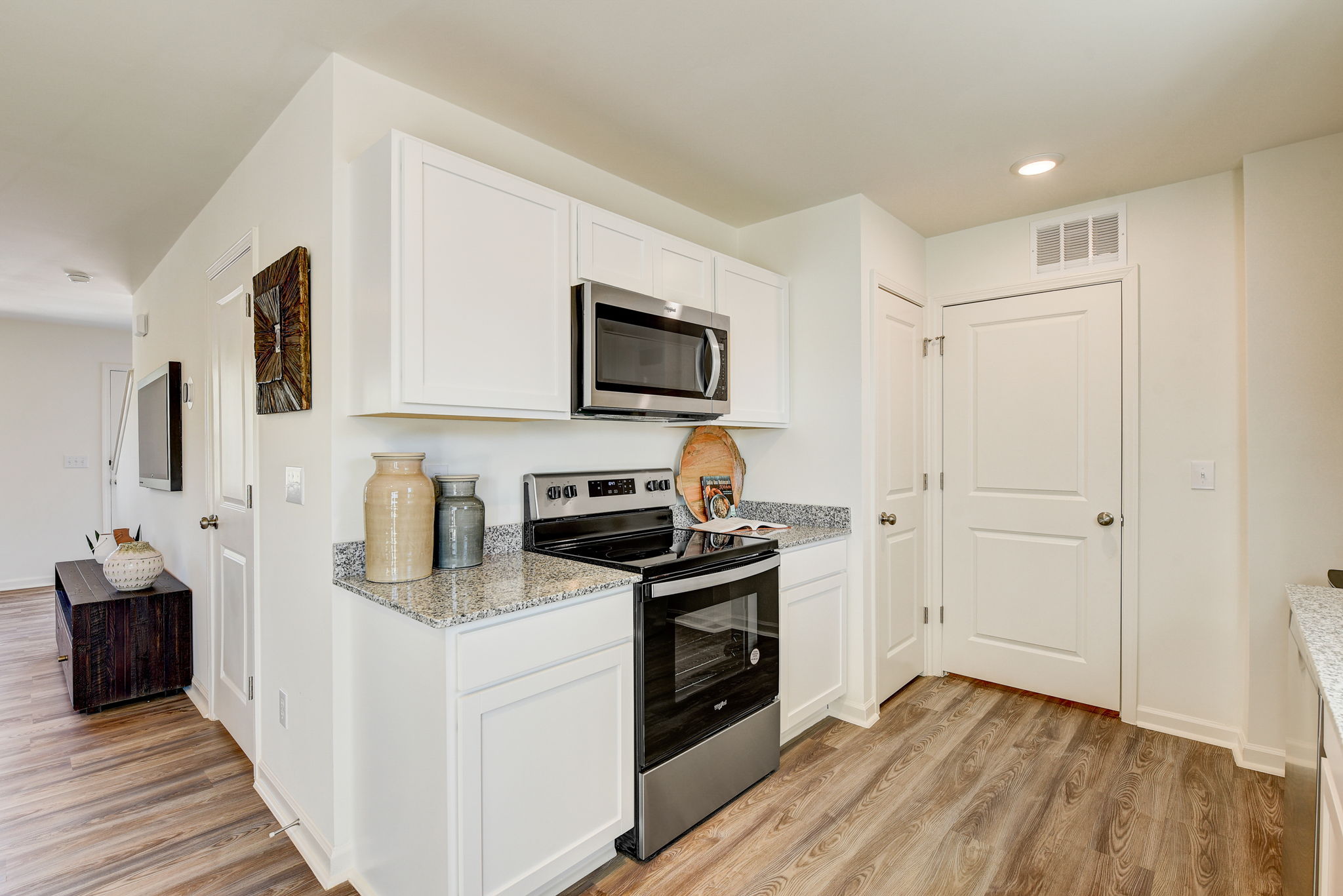 A kitchen with white cabinets.