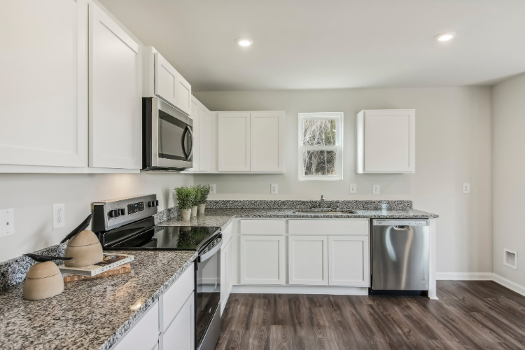 A kitchen with white cabinets.