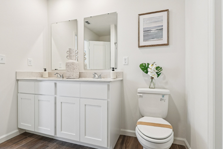 A bathroom with white cabinets.