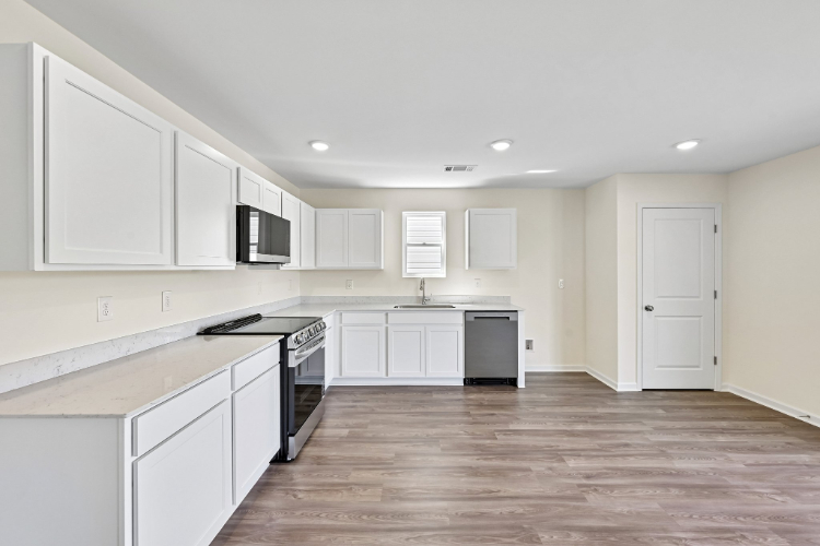 A kitchen with white cabinets.