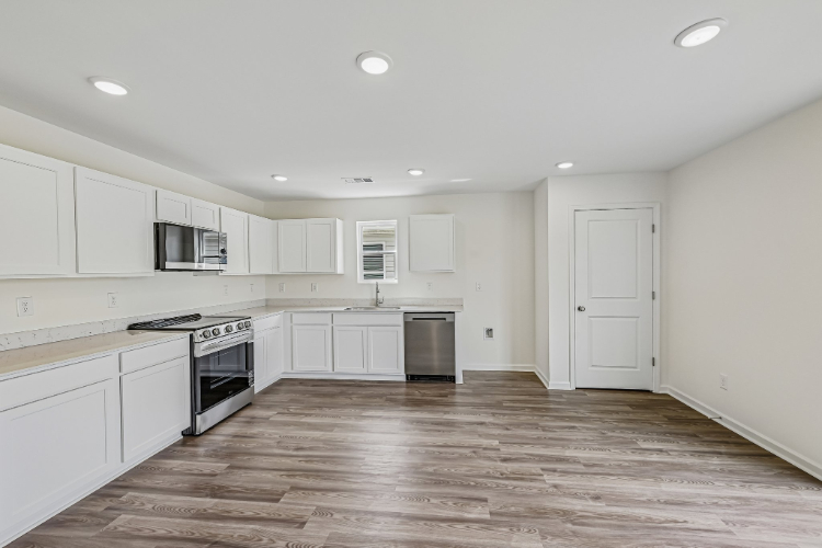 A kitchen with white cabinets.