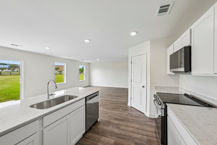 A kitchen with white cabinets.