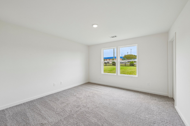 A room with a window and a green field.