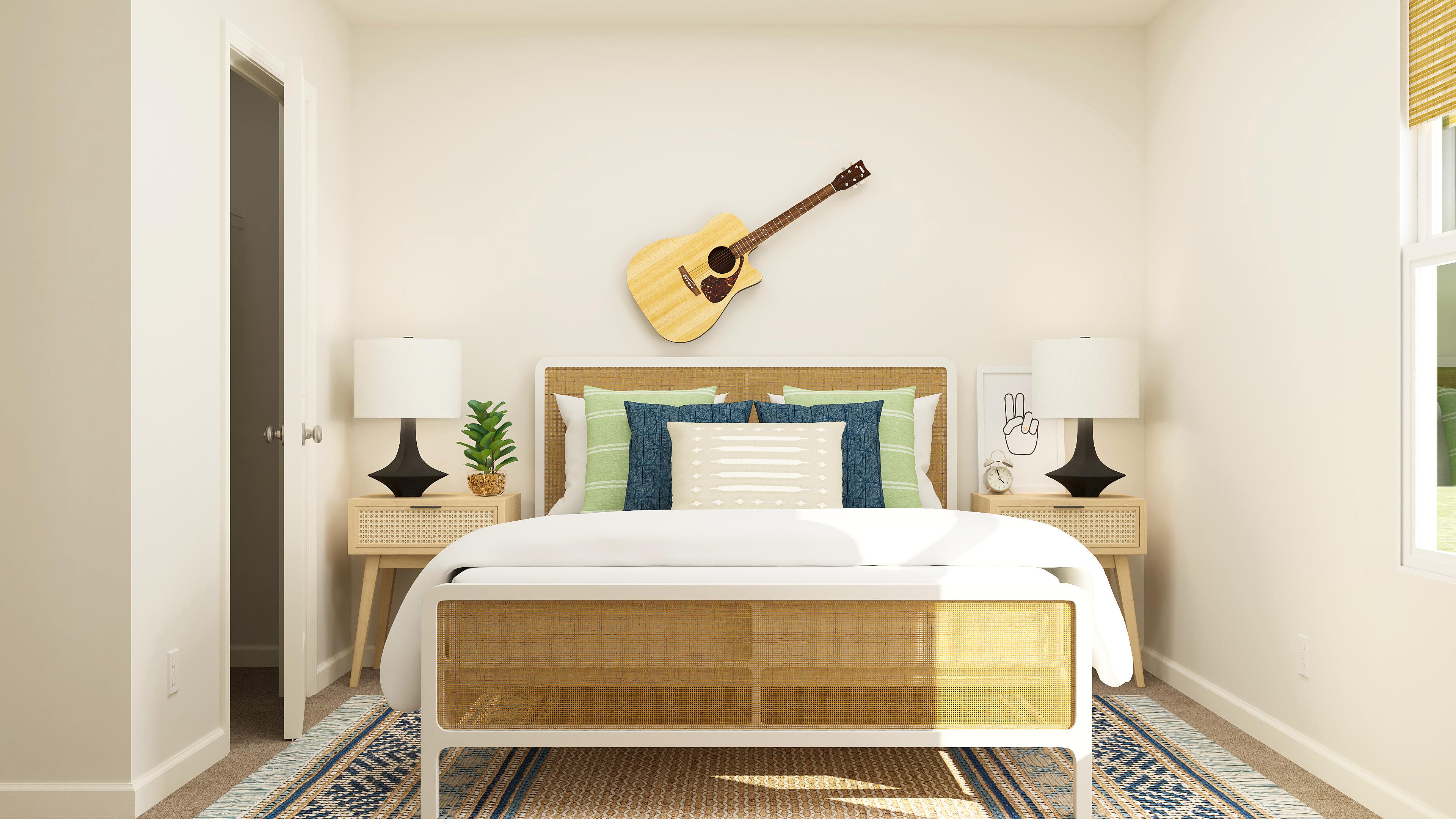 A bed with a guitar on the wall.