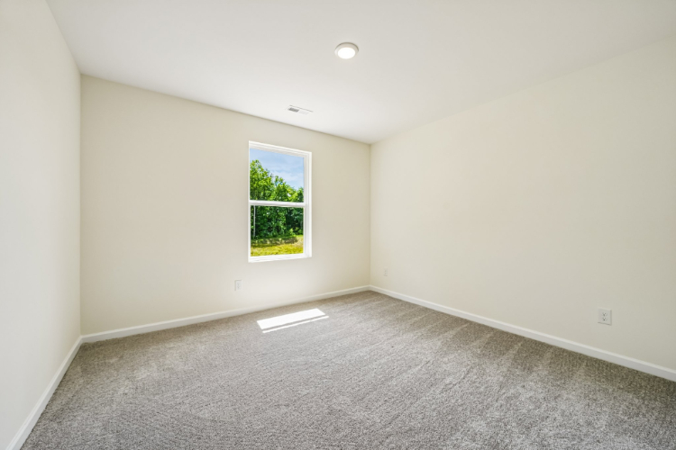 A room with a window and a light on the wall.