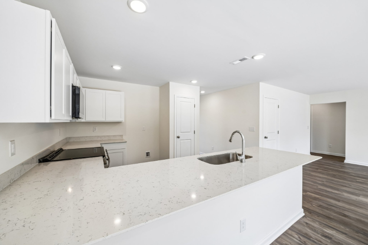 A kitchen with white cabinets.