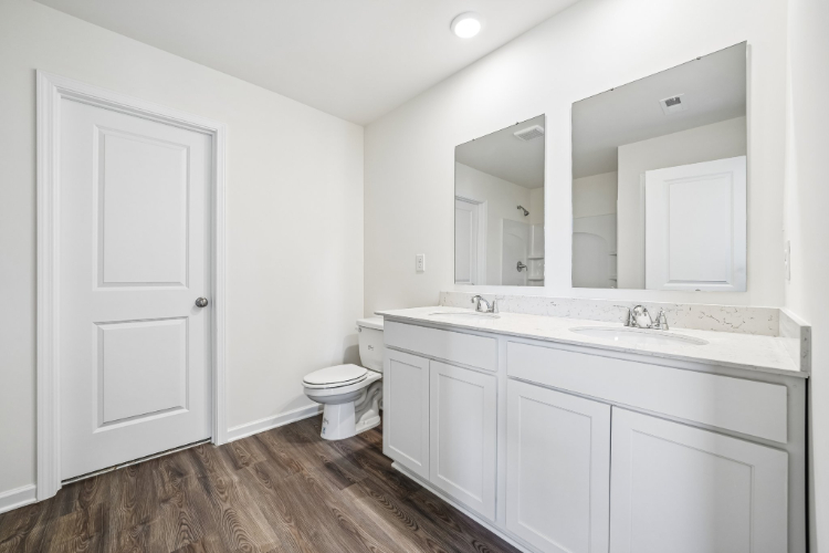 A bathroom with white cabinets.