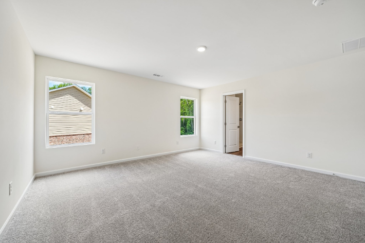 A room with a carpet and a door.