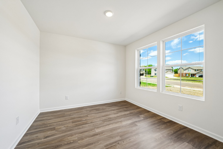 A room with a wood floor and a window with a wood floor.