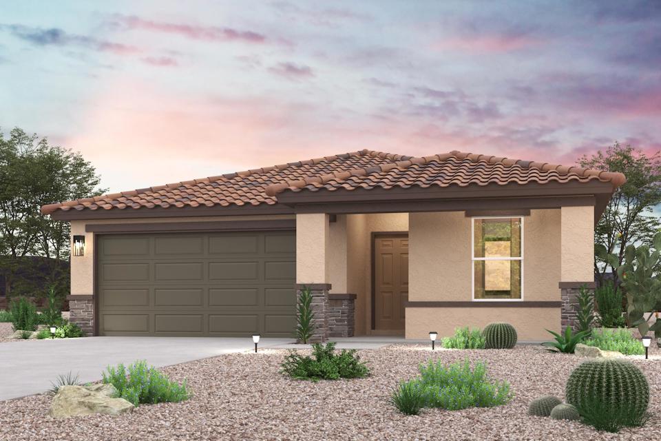 A house with a garage and bushes in front of it.