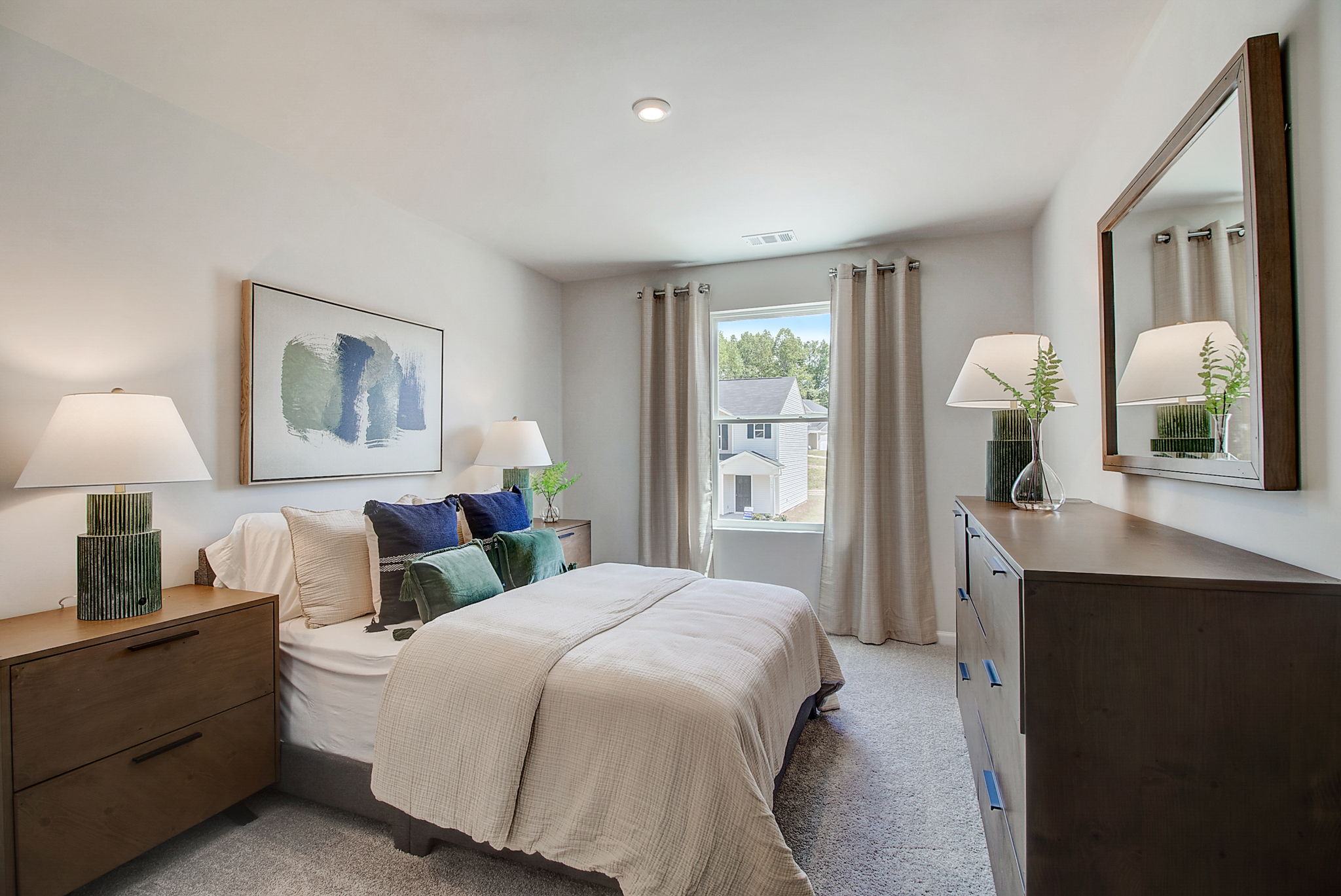 A bedroom with a large mirror.